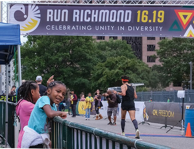 Siblings Kennedy Williams, left, and Madison Williams cheer Saturday for runners during Run Richmond 16.19, a cultural event that the Djimon Hounsou Foundation hosts in collaboration with the Black History Museum & Cultural Center of Virginia and Sports Backers.
