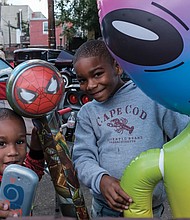 Caleb Wilson, 3, and Caiden Wilson, 7, smile for the camera while their mother, Simone Wilson, keeps a watchful eye on them.