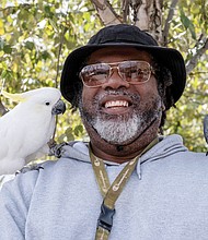 Julius Fillyow gets a visit from Cockatoos Bindi, left, and Coco, right, who were hanging out with owners Lucus Griffith and Lindsey Pennington.