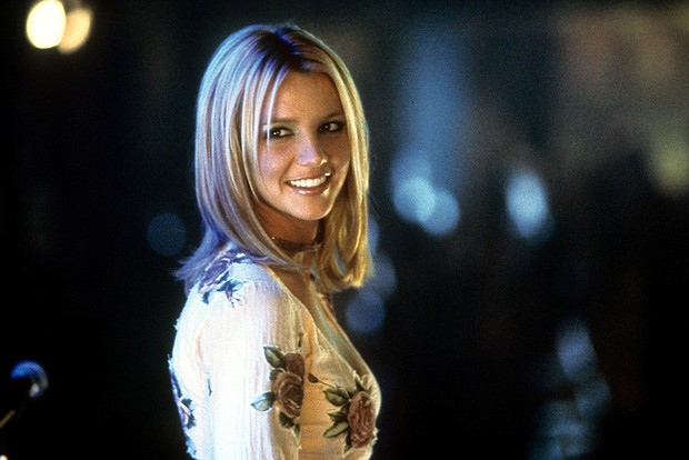 Britney Spears smiling as she looks back in a scene from the 2002 film "Crossroads." “Crossroads” is returning to theaters in celebration of Spears' new memoir “The Woman in Me."
Mandatory Credit:	Paramount/Moviepix/Getty Images