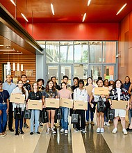 Participants smile alongside Comcast representatives after the resume building session