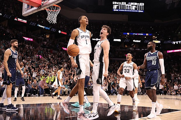 Victor Wembanyama and his San Antonion Spurs teammate Cedi Osman celebrate after a Wembanyama dunk in the fourth quarter against the Dallas Mavericks.
Mandatory Credit:	Christian Petersen/Getty Images