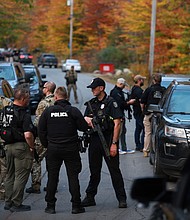 Law enforcement officials gather in the road leading to the home of the suspect being sought in connection with two mass shootings on October 26, 2023 in Bowdoin, Maine.
Mandatory Credit:	Joe Raedle/Getty Images