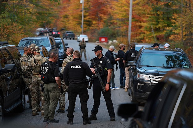 Law enforcement officials gather in the road leading to the home of the suspect being sought in connection with two mass shootings on October 26, 2023 in Bowdoin, Maine.
Mandatory Credit:	Joe Raedle/Getty Images