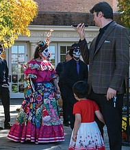 A youngster is intrigued by garden visitors celebrating Día de Los Muertos,  at Lewis Ginter Botanical Garden on Saturday, Oct. 28.