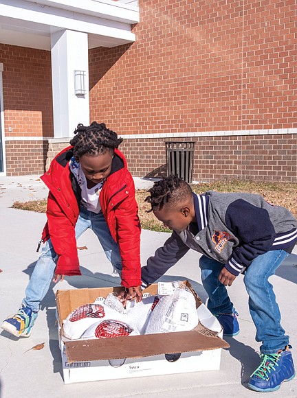 Brothers Darian Threatts, 7, and Dermon Threatts, 8, volunteer for the “Michael Jones Presents The Giveback: Turkey Giveaway,” providing some 1,000 Richmond families, seniors and organizations with a free turkey in time for Thanksgiving. This year’s event took place Nov. 18 at River City Middle School, 6300 Hull Street Road.