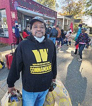William Jones carries his grocery haul from the Meadowbridge Community Market.