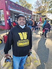 William Jones carries his grocery haul from the Meadowbridge Community Market.