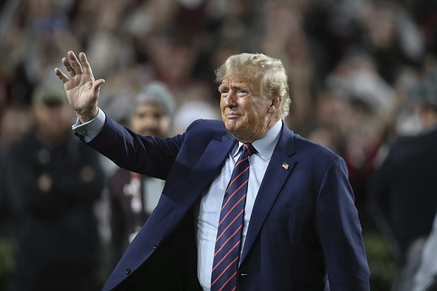 Former Republican President Donald Trump waves to the crowd Nov. 25 during halftime at an NCAA college football game between the University of South Carolina and Clemson in Columbia, S.C.