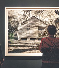 Museum visitors viewing the photograph Cabin from the series In This Here Place, 2019, Dawoud Bey (American, born 1953), gelatin silver print. Rennie Collection, Vancouver. Photo by Sandra Sellars, © 2023 Virginia Museum of Fine Arts.