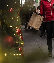 A woman carrying a shopping bag passes Macy's department store in Herald Square, on Dec. 11, in New York.
Mandatory Credit:	Yuki Iwamura/AP