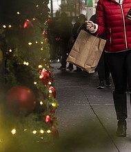 A woman carrying a shopping bag passes Macy's department store in Herald Square, on Dec. 11, in New York.
Mandatory Credit:	Yuki Iwamura/AP