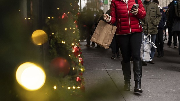 A woman carrying a shopping bag passes Macy's department store in Herald Square, on Dec. 11, in New York.
Mandatory Credit:	Yuki Iwamura/AP