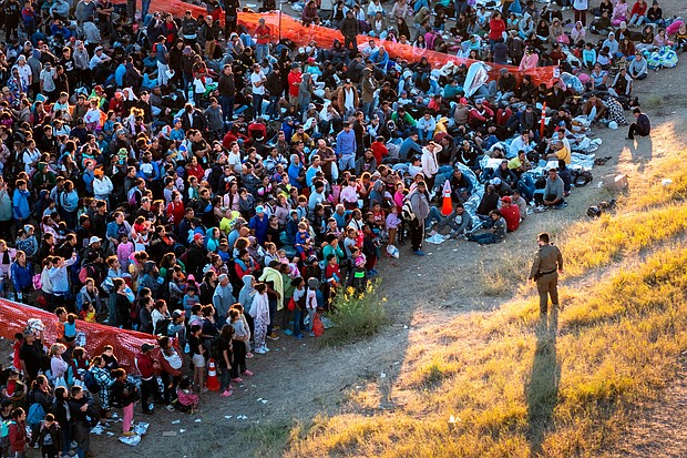 A US Border Patrol agent watches over migrants waiting to be processed after crossing from Mexico into the United States on December 17 in Eagle Pass, Texas.
Mandatory Credit:	John Moore/Getty Images