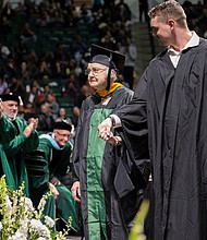 Minnie Payne, 90, is escorted across the stage by her grandson, Payne Billings./Courtesy Ahna Hubnik/University of North Texas
