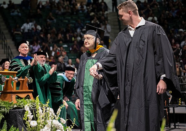 Minnie Payne, 90, is escorted across the stage by her grandson, Payne Billings./Courtesy Ahna Hubnik/University of North Texas