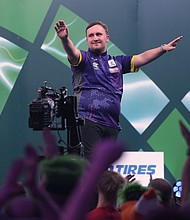 Luke Littler celebrates his quarterfinal win in front of the Alexandra Palace crowd.
Mandatory Credit:	Kin Cheung/AP