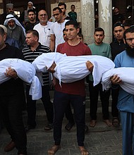 Relatives carry the bodies of children from the Abu Quta family who were killed in Israeli strikes on the Palestinian city of Rafah in the southern Gaza Strip, during their funeral in October 2023.
Mandatory Credit:	Said Khatib/AFP/Getty Images