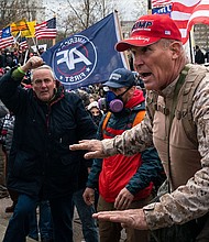 Ray Epps, in the red Trump hat, center, gestures to a line of law enforcement officers, as people gather on the West Front of the U.S. Capitol on January 6, 2021 in Washington, DC.
Mandatory Credit:	Kent Nishimura/Los Angeles Times/Getty Images