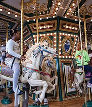 Families and friends enjoy an indoor carousel last month at the Children’s Museum of Richmond.