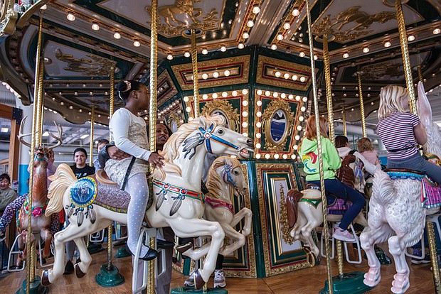 Families and friends enjoy an indoor carousel last month at the Children’s Museum of Richmond.