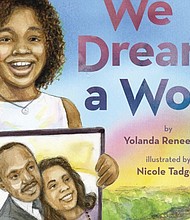 This cover image released by Scholastic shows “We Dream a World” by Yolanda Renee King, granddaughter of Coretta Scott King and Martin Luther King Jr. The book was released on Jan. 2.