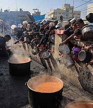 People wait for food relief in the southern Gaza Strip city of Rafah, on December 31, 2023.
Mandatory Credit:	Rizek Abdeljawad/Xinhua/Getty Images/File