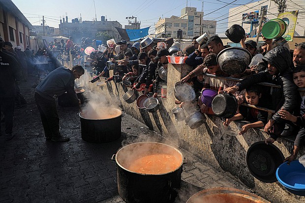 People wait for food relief in the southern Gaza Strip city of Rafah, on December 31, 2023.
Mandatory Credit:	Rizek Abdeljawad/Xinhua/Getty Images/File