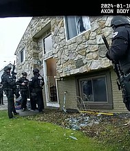 A body-worn camera footage still shows Elyria Police Department officers gathered outside a home during a raid on January 10.
Mandatory Credit:	City of Elyria