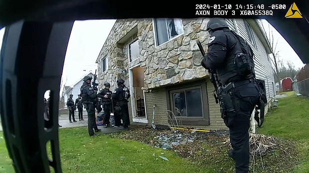 A body-worn camera footage still shows Elyria Police Department officers gathered outside a home during a raid on January 10.
Mandatory Credit:	City of Elyria