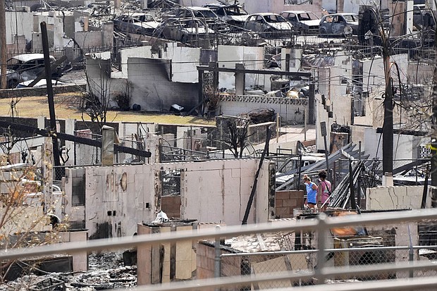 Two people examine a burned house on August 13, 2023, after a fire destroyed much of the historic Maui resort town of Lahaina in Hawaii.
Mandatory Credit:	Sandy Hooper/USA TODAY/Reuters