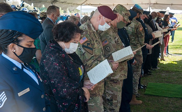 Military and civilian personnel bow their heads during the Port Tampa Cemetery Service of Remembrance at the MacDill Air Force Base on February 23, 2021.
Mandatory Credit:	Airman 1st Class David McLoney/US Air Force