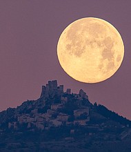 The wolf moon can be seen setting behind the castle of Rocca Calascio in the Abruzzo region of Italy, on January 7, 2023.
Mandatory Credit:	Lorenzo Di Cola/NurPhoto/Getty Images