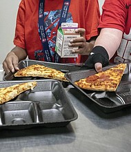 Students select their meals during lunch break in the cafeteria on Dec. 12, 2022, at an elementary school in Scottsdale, Ariz. A bill that would provide free meals for all public school students in Virginia passed the Senate Education and Health Committee last week. The proposal would cost an estimated $346 million over the next two years.