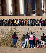 Migrants wait in front of barbed wire in Ciudad Juarez, Mexico on December 29, 2023.
Mandatory Credit:	David Peinado/Anadolu/Getty Images