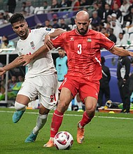 Mohammed Rashid of the Palestinian soccer team and Mohammad Mohebbi of Iran compete for the ball during the AFC Asian Cup Group C match between Iran and Palestine at Education City Stadium on January 14 in Al Rayyan, Qatar.
Mandatory Credit:	Masashi Hara/Getty Images
