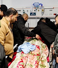 Mourners grieve next to the body of a Palestinian man killed in the raid.
Mandatory Credit:	Raneen Sawafta/Reuters