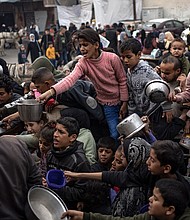Palestinians line up for a free meal in Rafah, Gaza Strip, Thursday, December 21, 2023.
Mandatory Credit:	Fatima Shbair/AP