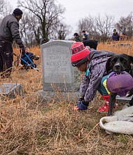While William Dunn, 4, helps clean up Evergreen Cemetery, Teacake is only interested in playing during Friends of East End Cemetery’s Martin Luther King Jr. Day of Service on Jan. 17.