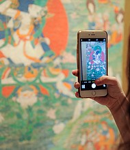 A guest takes a photo of Buddhist artwork during the 2016 Asia Week Celebration at Rubin Museum of Art on March 17, 2016.
Mandatory Credit:	Matthew Eisman/Getty Images