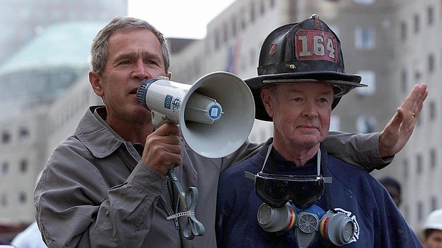 President George W. Bush, left, stands next to retired New York Fire Department firefighter Bob Beckwith on September 14, 2001, three days after the 9/11 terror attacks.
Mandatory Credit:	Paul Richards/AFP via Getty Images