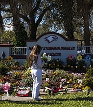 People visit a memorial at Marjory Stoneman Douglas High School to honor those killed on the 5th anniversary of the mass shooting on February 14, 2023, in Parkland, Florida. in February 2018, fourteen students and three staff members were killed during the shooting at the school.
Mandatory Credit:	Saul Martinez/Getty Images/File