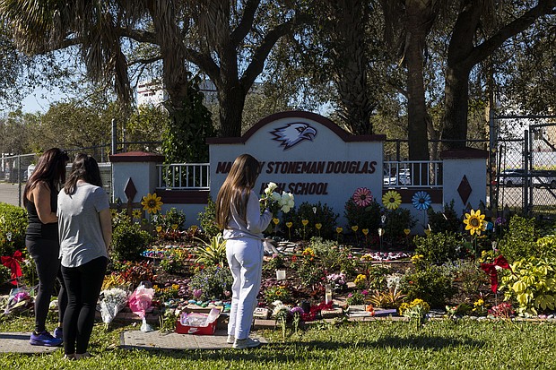 People visit a memorial at Marjory Stoneman Douglas High School to honor those killed on the 5th anniversary of the mass shooting on February 14, 2023, in Parkland, Florida. in February 2018, fourteen students and three staff members were killed during the shooting at the school.
Mandatory Credit:	Saul Martinez/Getty Images/File