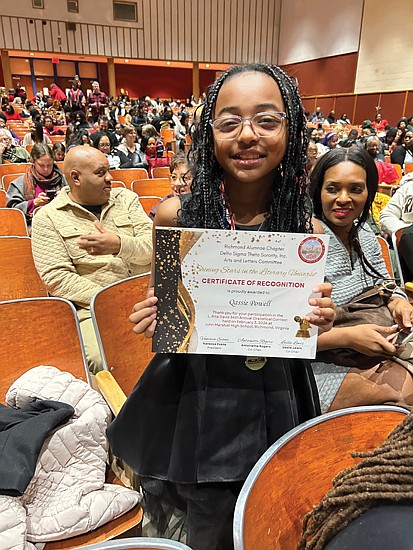 Qassie Powell of Miles Jones Elementary School displays her certificate from the Oratorical Contest.