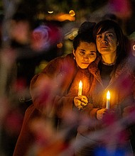 People clutch candles during a vigil on the one-year anniversary of a mass shooting on January 21, 2024, in Monterey Park, California.
Mandatory Credit:	Ringo Chiu/AP