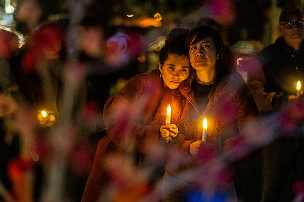 People clutch candles during a vigil on the one-year anniversary of a mass shooting on January 21, 2024, in Monterey Park, California.
Mandatory Credit:	Ringo Chiu/AP
