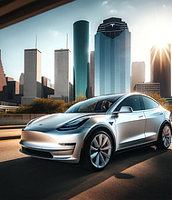 Tesla Model Y with a matte white wrap is parked in front of the Houston skyline.