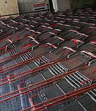 A shopper wearing a protective face mask walks past a shopping cart corral outside of a Costco store amid the coronavirus disease (COVID-19) outbreak in Wheaton, Maryland, in May 2020.
Mandatory Credit:	Tom Brenner/Reuters/FILE