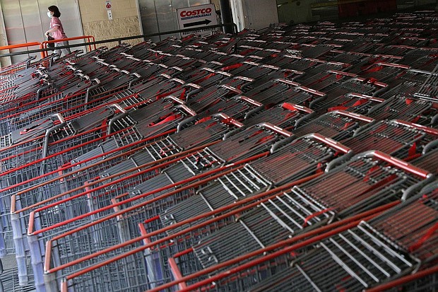 A shopper wearing a protective face mask walks past a shopping cart corral outside of a Costco store amid the coronavirus disease (COVID-19) outbreak in Wheaton, Maryland, in May 2020.
Mandatory Credit:	Tom Brenner/Reuters/FILE