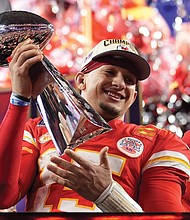 Kansas City Chiefs quarterback Patrick Mahomes celebrates with the trophy Sunday after the team’s overtime win during Super Bowl LVIII against the San Francisco 49ers in Las Vegas. Behind him is Kansas City Chiefs Coach Andy Reid. The Chiefs won 25-22.